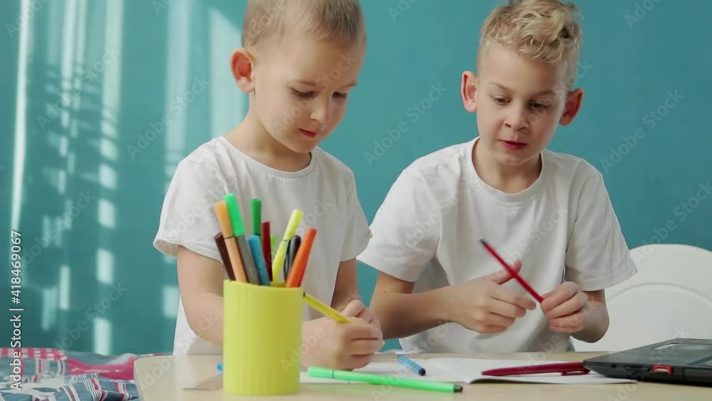 A little boys choosing pencil and doing homework on table in living room. Quarantine drawing A little boys choosing pencil and doing homework on table in living room. Quarantine drawing