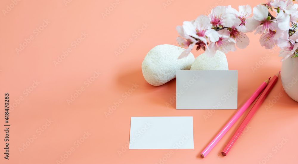 Mockup template of business card, pensils and natural elements on the pink background. Beautiful almond flowers and white stones. Banner photo, space for text or logo or any information. Mockup template of business card, pensils and natural elements on the pink background. Beautiful almond flowers and white stones. Banner photo, space for text or logo or any information.