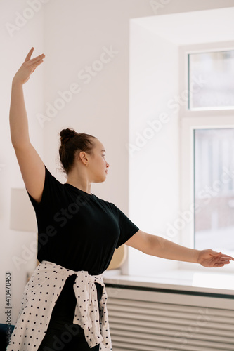 Teenager girl practicing ballet online classes at home. Woman dancing indoors