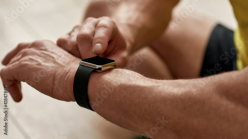 Workout results. Cropped shot of a mature man looking at his smart watch while exercising at home