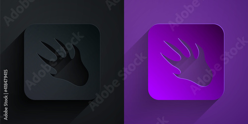 Paper cut Alligator crocodile paw footprint icon isolated on black on purple background. Paper art style. Vector.