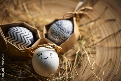 Cute angel Easter egg and stylish minimalistic eggs on hay, greeting festive card on springtime religious holiday photo