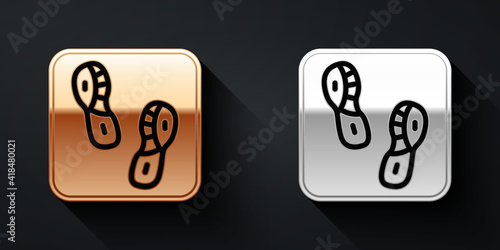 Gold and silver Human footprints shoes icon isolated on black background. Shoes sole. Long shadow style. Vector.