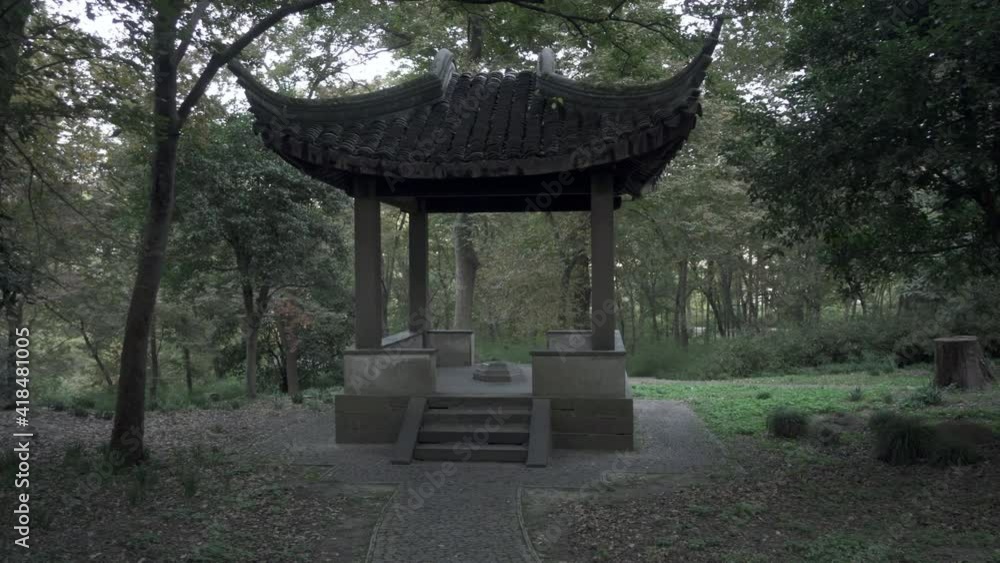 Panning shot of empty gazebo amidst green trees and plants at park - Suzhou, China Panning shot of empty gazebo amidst green trees and plants at park - Suzhou, China