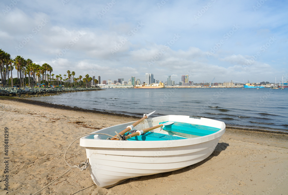 Lovely white boat on sandy beach with bay view and city