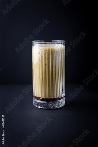 Frappe coffee in the glass on the black background