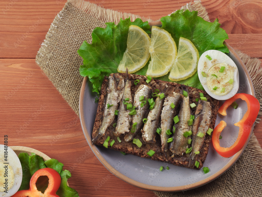 Фотография grilled sprat sandwich, lemon, egg