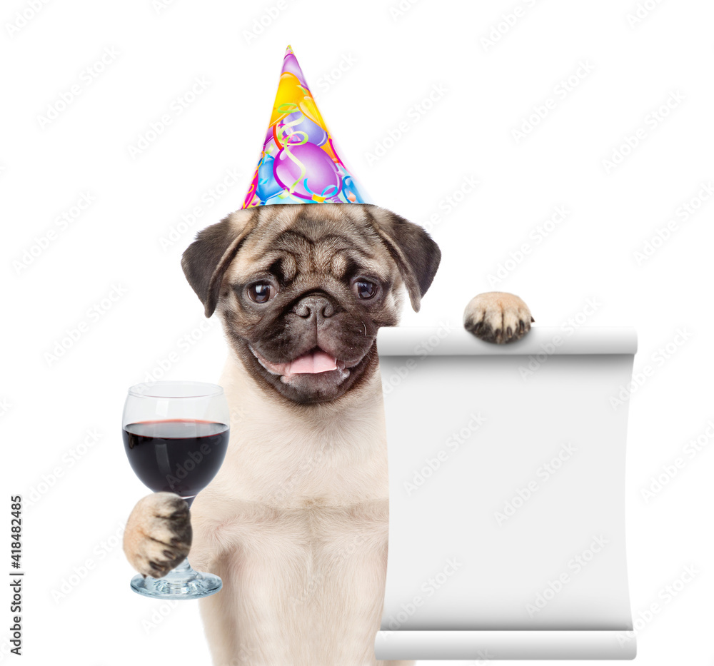 Dog wearing party cap holds glass of red wine and empty list. isolated on white background