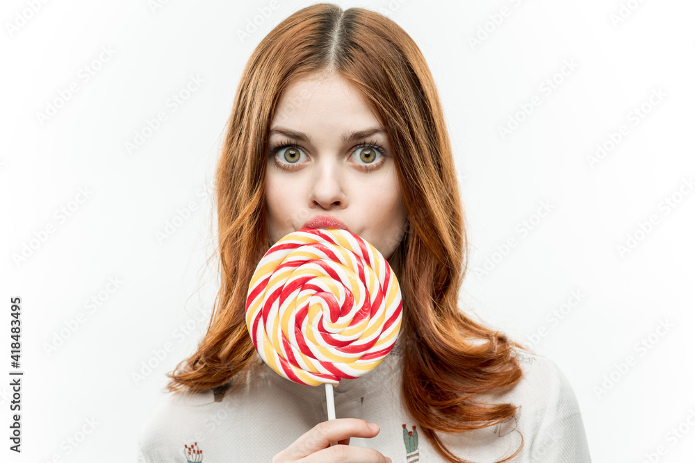 pretty red-haired woman with multicolored lollipop near face cropped view of sweets emotions