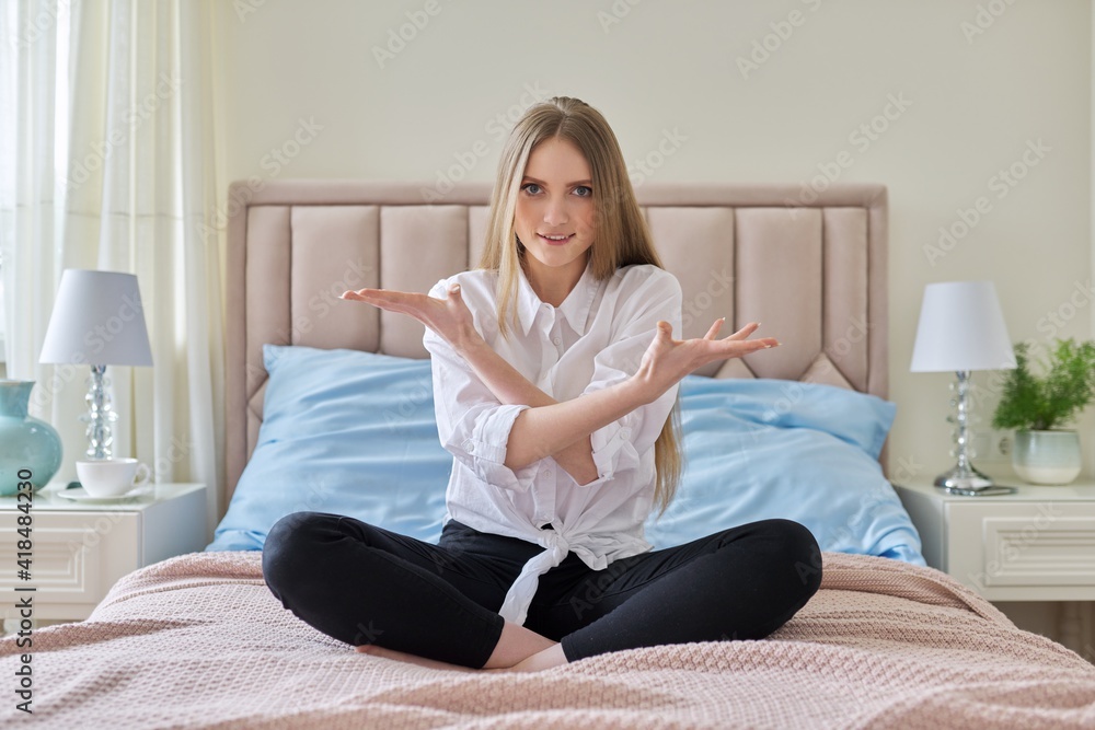 Serious anxious worried young woman sitting at home in bed Serious anxious worried young woman sitting at home in bed