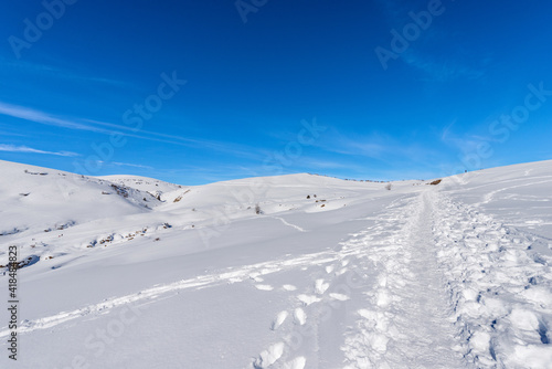 Snowy footpath in winter on the Lessinia Plateau (Altopiano della Lessinia), Regional Natural Park, near Malga San Giorgio, ski resort in Verona province, Bosco Chiesanuova, Veneto, Italy, Europe. © Alberto Masnovo