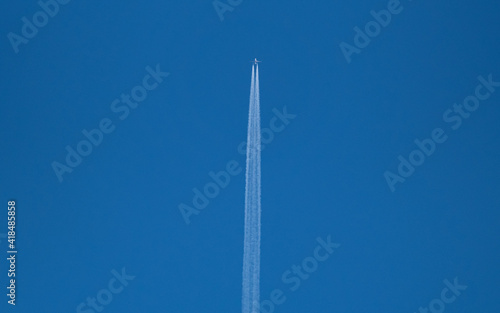An airplane in a blue sky at a sunny day in corona times