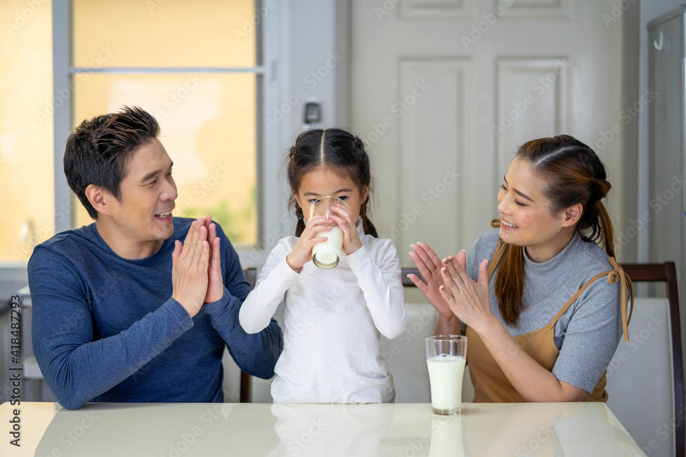 Happy family mother, father, child baby daughter having milk at home. Happy family mother, father, child baby daughter having milk at home.