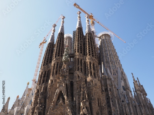 BARCELONA, SPAIN on SEPTEMBER 2019: Front of cathedral Sagrada Familia under construction in european city at Catalonia district, clear blue sky in warm sunny summer day.