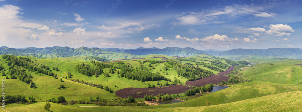 Panoramic view of green hills and blue sky with clouds, countryside