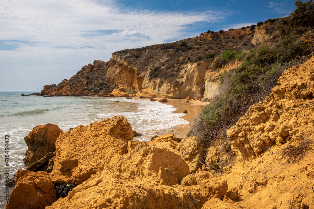 View of the Le Pergole beach in Sicily. The colorful rocks contrast beautifully with the color of the sea. A warm summer afternoon.