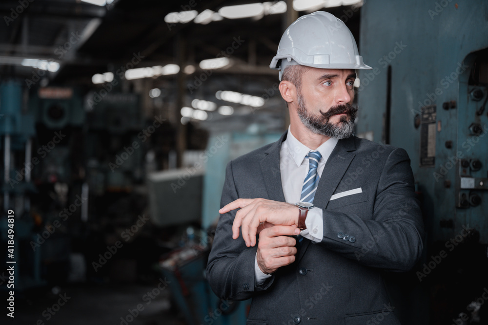 Portrait of confident business people wearing hardhats in metal factory Portrait of confident business people wearing hardhats in metal factory