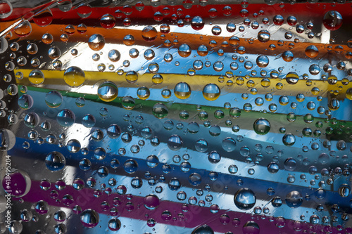 Raindrops fall through an open window with rainbow jalousie against the background of a cloudy sky. Abstract fantasy. 3D render.