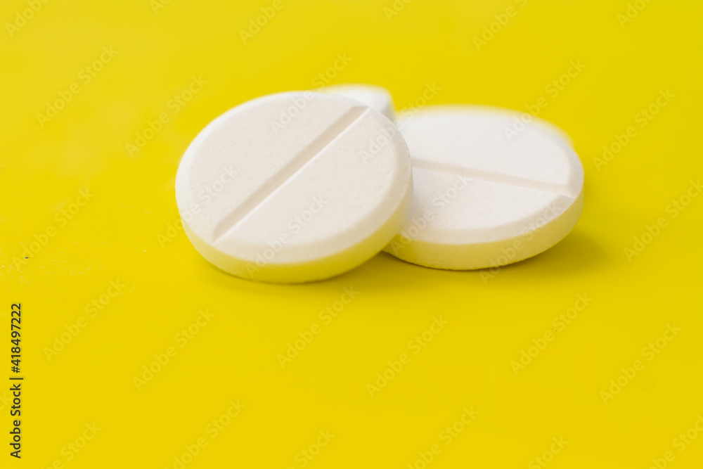 White round medical pills on a colourful background. Scattered white pills on the table. The concept of medicine, pharmacy and healthcare. Space for text or logo. White round medical pills on a colourful background. Scattered white pills on the table. The concept of medicine, pharmacy and healthcare. Space for text or logo.
