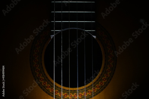 beautiful acoustic wooden guitar close up in the dark