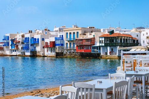 Beautiful Little Venice, Mykonos, Greece. Romantic neighborhood with whitewashed bars, cafes, restaurants. Colorful tables and chairs by shoreline