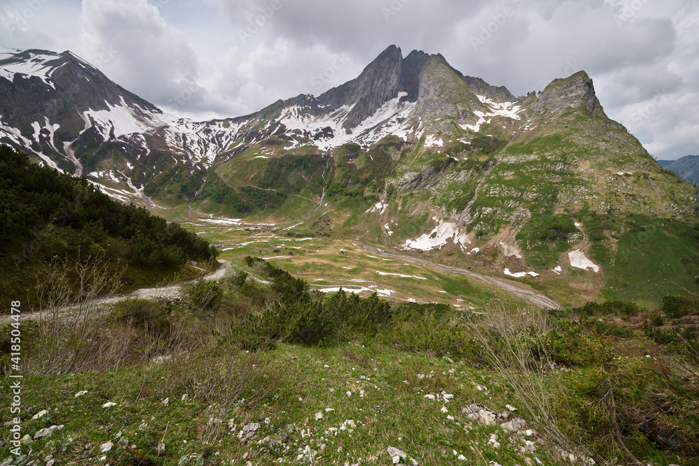 Dicke Regenwolken im Frühsommer über der Berglandschaft des oberen Oytals