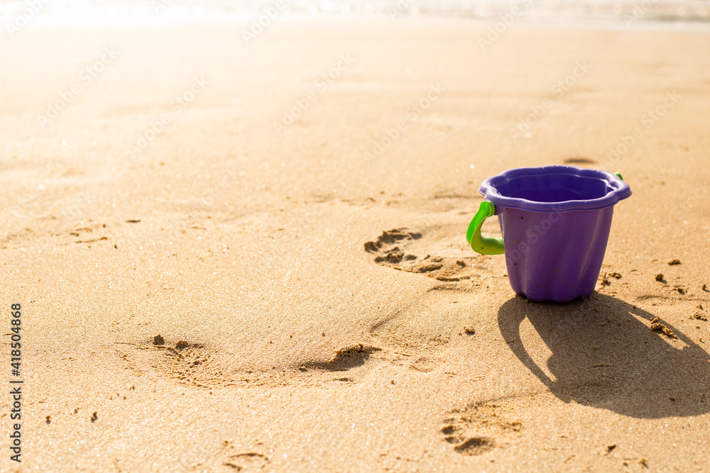 plastic toy bucket on the sand on a sunny day. plastic toy bucket on the sand on a sunny day.