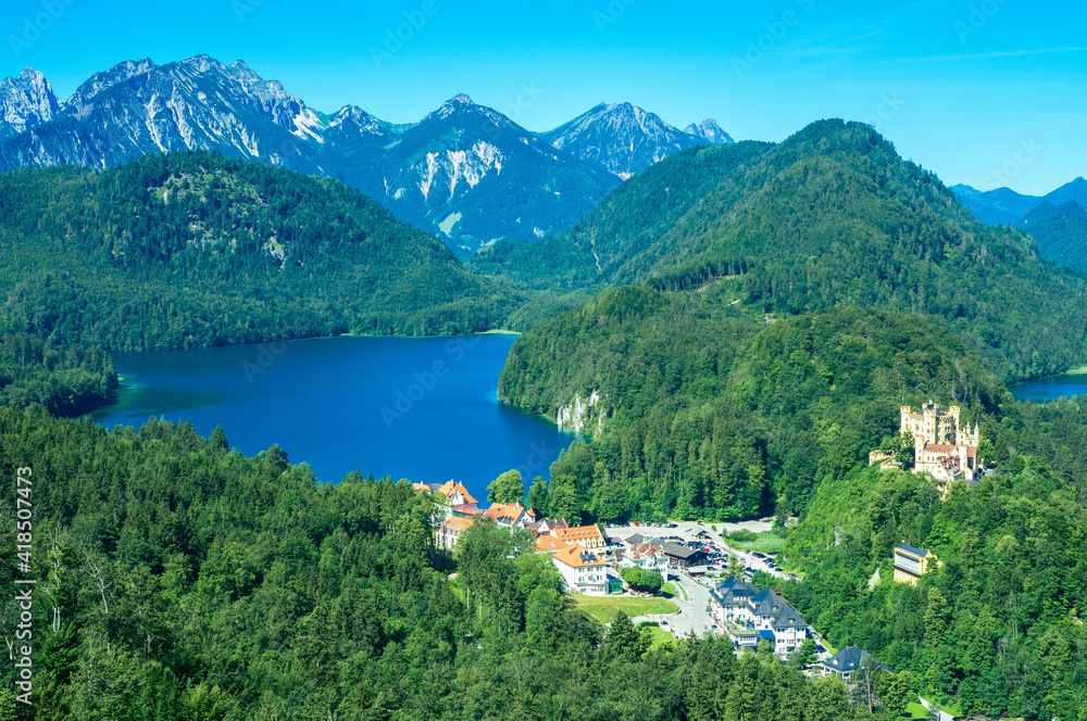Hohenschwangau Castle next to the lakes Schwansee and Alpsee, embedded within a beautiful and stunning alpine landscape in Bavaria, Germany, Europe
