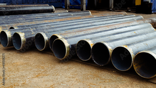 Raw Pipes Material Black Steel Laying on the Ground 