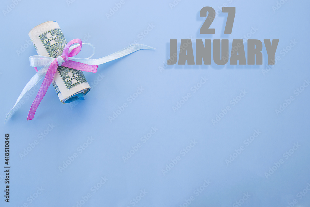 calendar date on blue background with rolled up dollar bills pinned by blue and pink ribbon with copy space. January 27 is the twenty-seventh day of the month