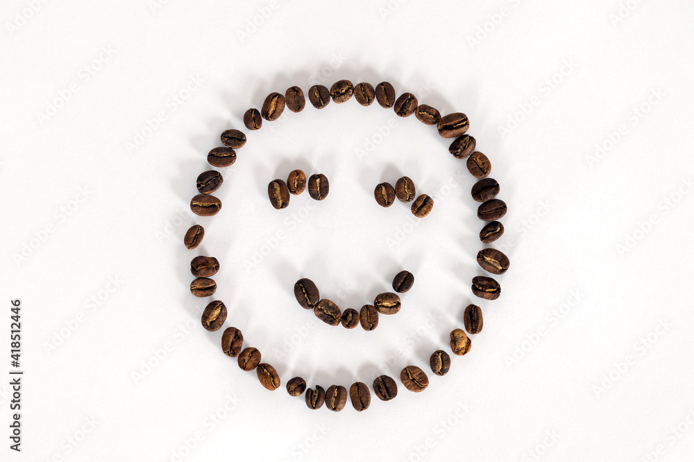 Artificial smiling face made from coffee beans on white background. Concept idea, copy space.