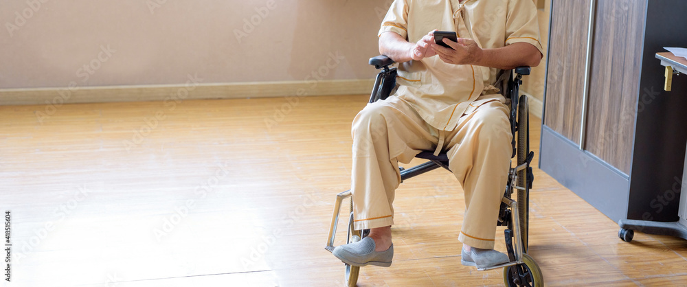 .Elderly uncle sitting with a mobile phone Inside the hospital room, clinic. .Elderly uncle sitting with a mobile phone Inside the hospital room, clinic.