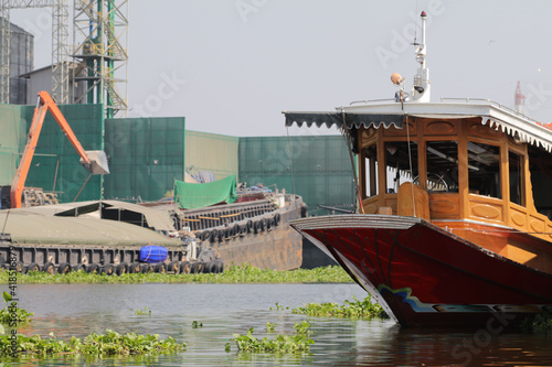 An ancient Kampan boat in Thailand, aged 60-70 years, decorated in a modern but classic style to receive tourists who like water tourism and traditional Thai lifestyle. photo