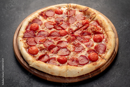 pepperoni pizza with ingredients on stone background