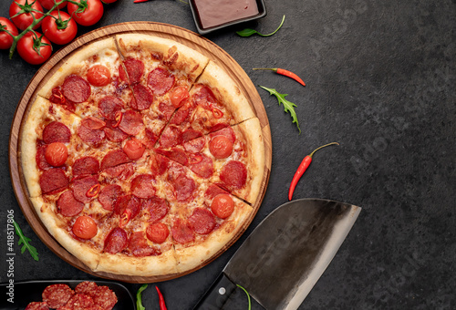 pepperoni pizza with ingredients on stone background