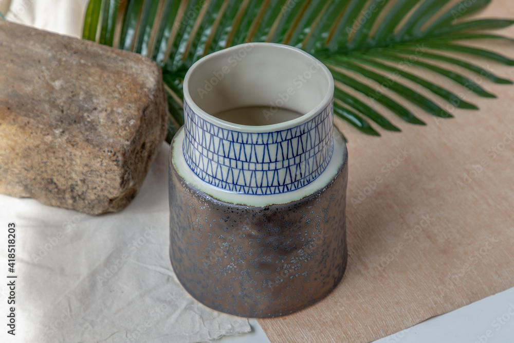 Handmade ceramic vase on white textured table cloth.  Home decor, Copy space, Selective focus.