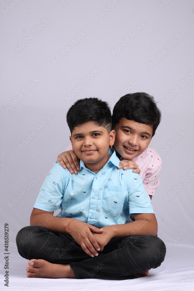 cheerful indian siblings hugging and posing for a photo. cheerful indian siblings hugging and posing for a photo.