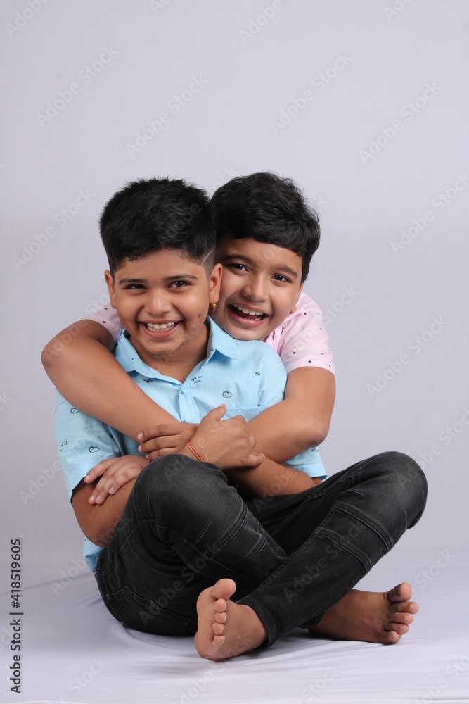 cheerful indian siblings hugging and posing for a photo. cheerful indian siblings hugging and posing for a photo.