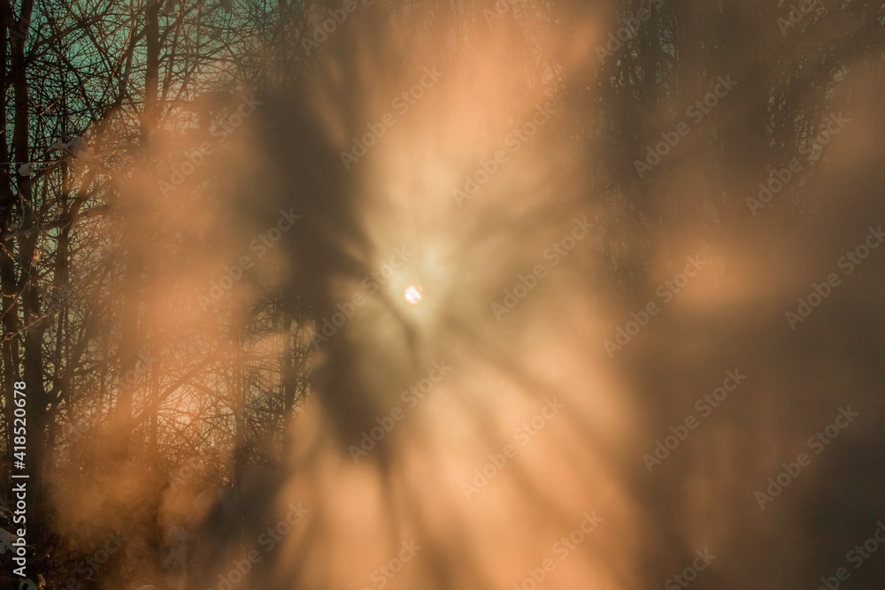 Obraz premium bright sun rays shine beautifully through the water mist on a frosty winter day
