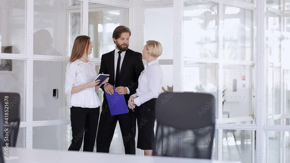 Smiling male and female colleagues communicate by holding a folder with a document. A friendly businessman and entrepreneur discussing the company's development strategy Smiling male and female colleagues communicate by holding a folder with a document. A friendly businessman and entrepreneur discussing the company's development strategy