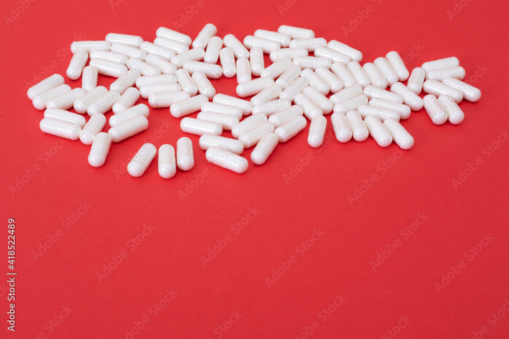 White pills on the red paper background. Epidemic virus. White pills on the red paper background. Epidemic virus.