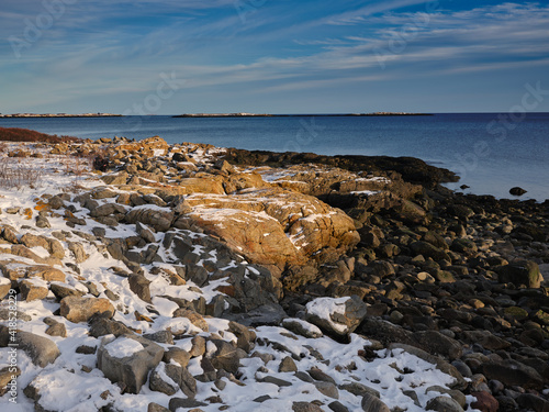 Low-tide on snow covered granite coastal rocks at the entrance to the St. George River in Maine