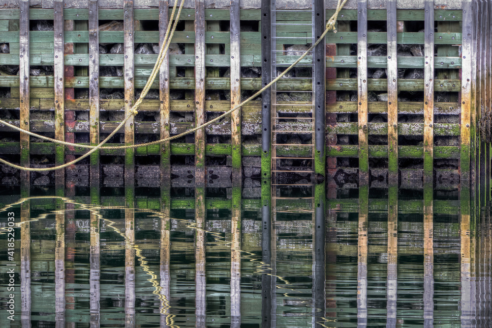 Wooden wharf structure with reflections in water Wooden wharf structure with reflections in water