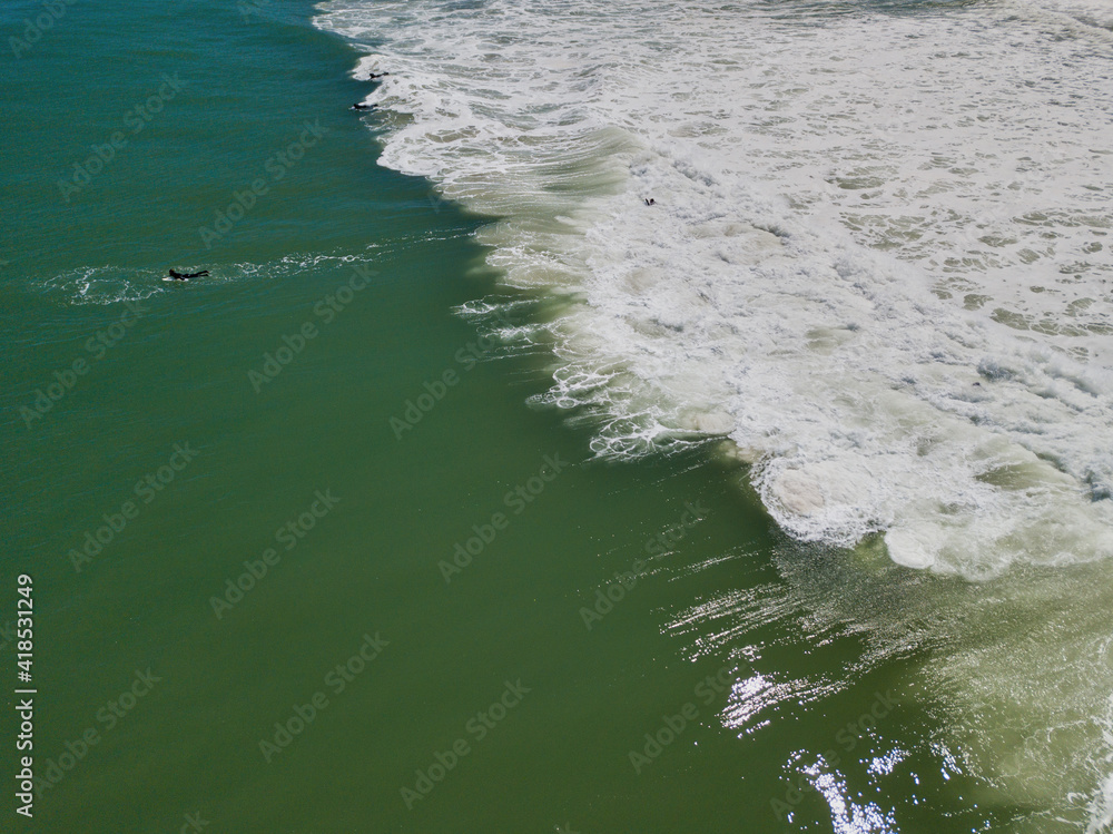 Aerial Drone image of Island Beach State Parks expansive sandy beaches on a perfect spring day with large foam breaker waves crashing onto the shoreline