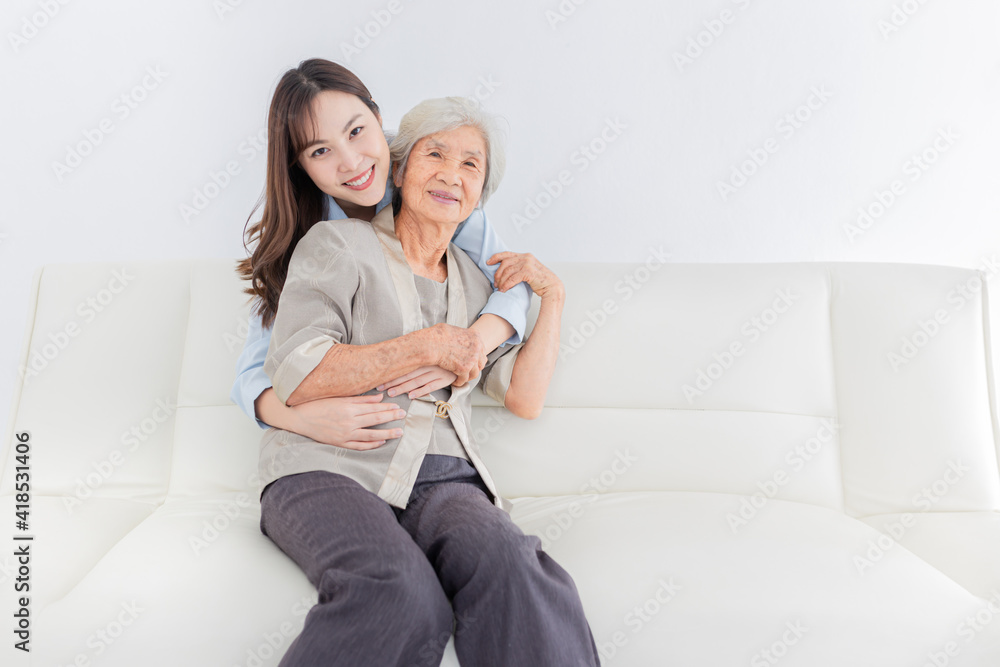 close up old woman, young Asian female hug old female in home, they feeling happy and smile, they sitting on sofa, mother's day, happiness elderly in family time
