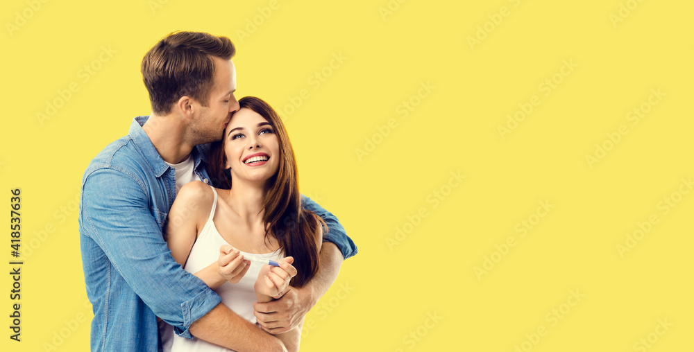 Love, new parents and family concept - very happy excited couple, finding out results of a pregnancy test. Studio portrait of young man and woman, isolated over yellow background. Love, new parents and family concept - very happy excited couple, finding out results of a pregnancy test. Studio portrait of young man and woman, isolated over yellow background.