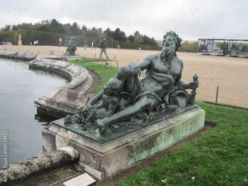 Beautiful sculpture in the Versailles Garden on a rainy day. Travel to European Union. UNESCO World Heritage Site.
