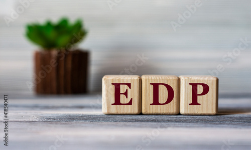 EDP - acronym on wooden cubes against the background of a light board with beautiful divorces and a cactus