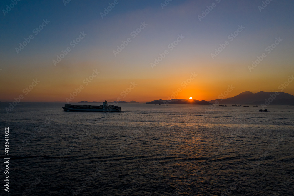 Cargo ship pass out Victoria Harbour at sunset