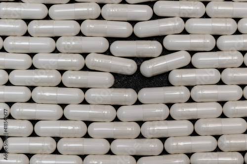 Background of medicines in the form of capsules lined in a brick style with a blank space